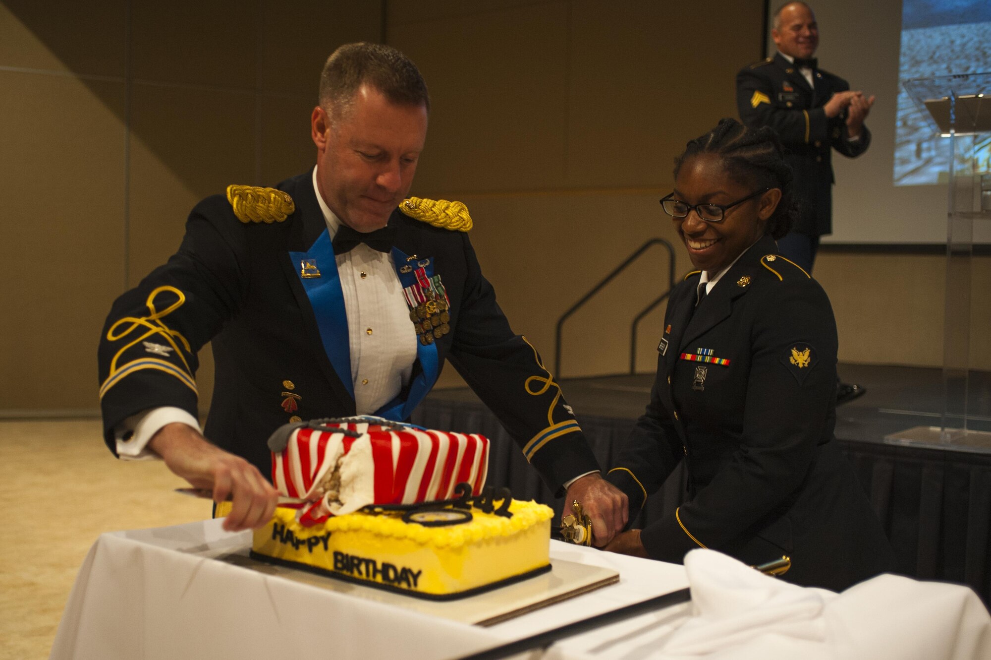 U.S. Army Col. Brian Lieb, and Spc Alantra Grigsby, 344th Military Intelligence Battalion, cut the party cake during the Army Ball at the McNease Convention Center San Angelo, Texas, June 16, 2017. Lieb and Alantra are the oldest and youngest (respectively) soldiers present at the ball, and tradition has them together cutting the cake. (U.S. Air Force photo by Senior Airman Scott Jackson/Released)