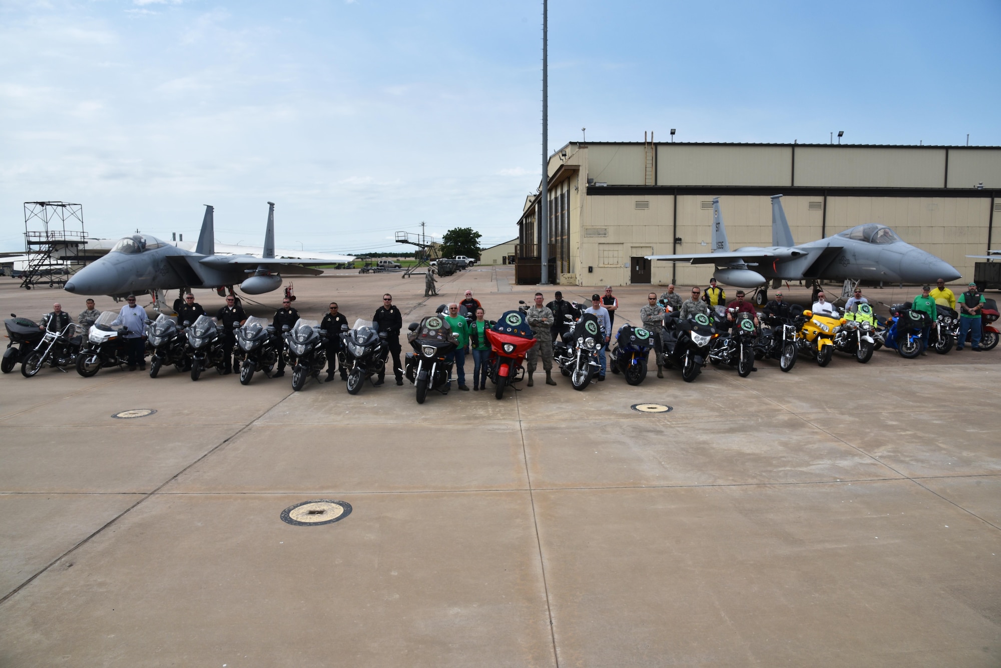 Chapter 54 of the Green Knights Military Motorcycle Club, Wichita Falls police officers and motorcyclists from Team Sheppard gather in front of two F-15 Strike Eagles, June 19, 2017. The GKMMC and the Sheppard safety office work together to educate new riders on base. (U.S. Air Force photo by 2nd Lt. Jacqueline Jastrzebski)