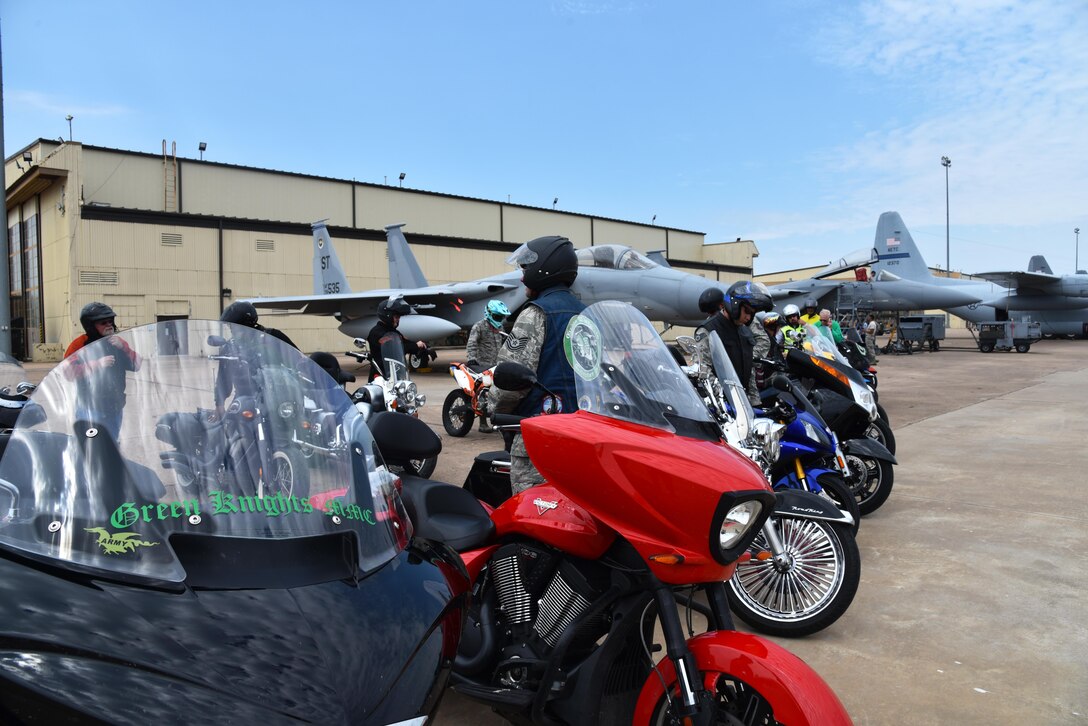 Motorcycle riders from Chapter 54 of the Green Knights Military Motorcycle Club and Sheppard Air Force Base mount their bikes in front of an F-15, June 19, 2017. The ride continued through base and ended with a burger and hot dog burn. (U.S. Air Force photo by 2nd Lt. Jacqueline Jastrzebski)