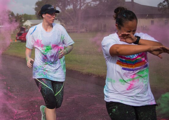 Runners sprinkled with color run through a cloud of colored chalk as they approach the finish line of the LGBT Pride Month 5K Color Run June 14 at Eglin Air Force Base, Fla. The run was held to celebrate diversity and raise inclusion awareness. (U.S. Air Force photo/Ilka Cole)