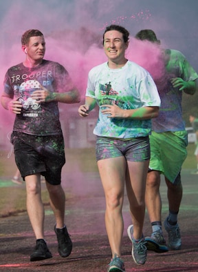 Runners sprinkled in color run through a cloud of colored chalk as they approach the finish line of the LGBT Pride Month 5K Color Run June 14 at Eglin Air Force Base, Fla. The run was held to celebrate diversity and raise inclusion awareness. (U.S. Air Force photo/Ilka Cole)