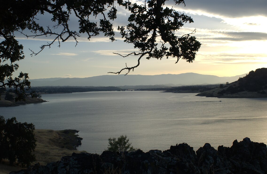 A lone boat makes its way along the shoreline as the sun begins to set at Black Butte Lake.