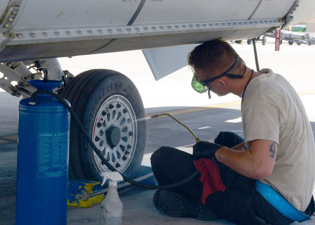 A crew chief from the 309th Aircraft Maintenance Unit cleans a wheel of an F-16 Fighting Falcon, June 13, 2017, at Luke Air Force Base, Ariz. Crew chiefs and maintainers perform all maintenance for the aircraft to be mission ready for pilots to fly. (U.S. Air Force photo by Senior Airman James Hensley)