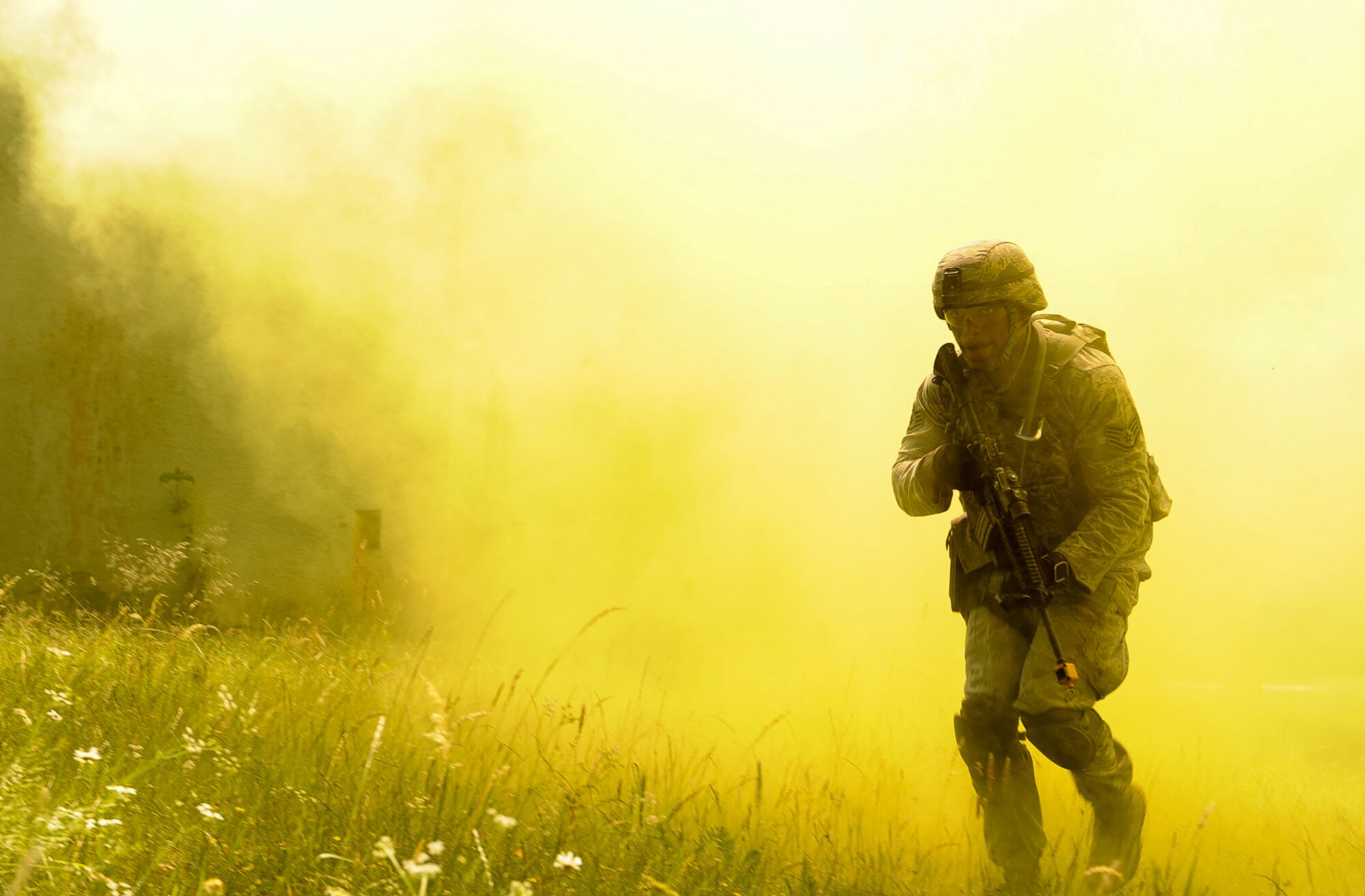Staff Sgt. Eric Jeffcoat, 100th Security Forces Squadron base defense operation center controller, emerges from smoke grenade smoke during 435th SFS’s Ground Combat Readiness Training Center Security Operations Course at U.S. Army Garrison Baumholder, Germany, June 15, 2017. Conducting missions as a team and being evaluated by the 435th SFS instructor cadre, students showcased knowledge of urban operations, close quarters combat, live firing iterations, mounted and dismounted patrols, entry control point operations, and counter improved-explosive device operations while at Baumholder. (U.S. Air Force photo by Airman 1st Class Savannah L. Waters)