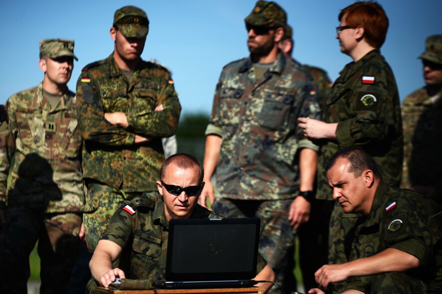 Polish Air Force Warrant Officer Marcin Galek, a weatherman, front left, operates a computer used for collecting weather data at McCully Barracks, Germany, June 15, 2017. Troops from Germany, Poland, and Hungary joined 7th Weather Squadron Airmen for Exercise Cadre Focus 17-1. This is the second year NATO allies participated in the exercise. (U.S. Air Force photo by Airman 1st Class Joshua Magbanua)
