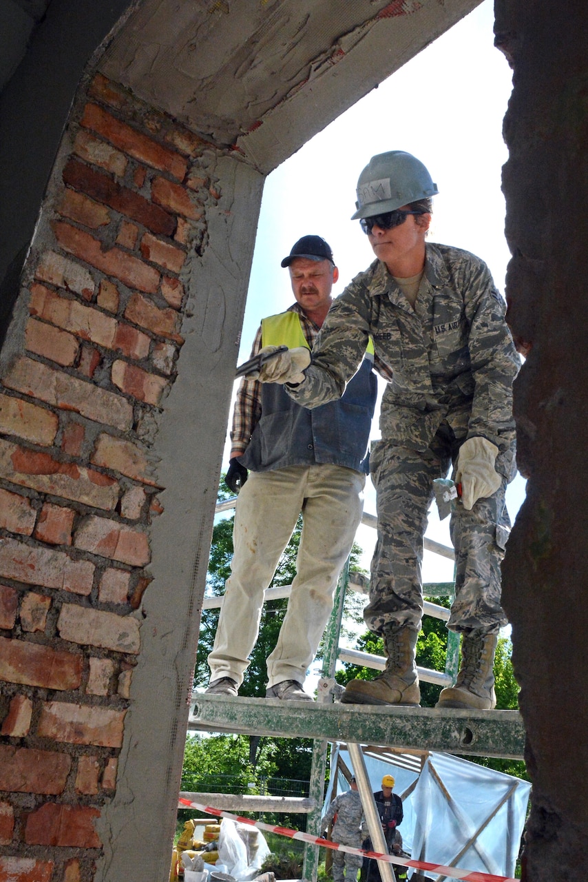 Air Force Senior Airman Samantha Ghareeb, a heavy equipment operator with the Kansas Air National Guard’s 190th Civil Engineer Squadron, applies mortar to a building in Daugavpils, Latvia, in June 2015. Ghareeb was part of a humanitarian project between her unit and Latvian military engineers. Kansas Air National Guard photo by Master Sgt. Allen Pickert