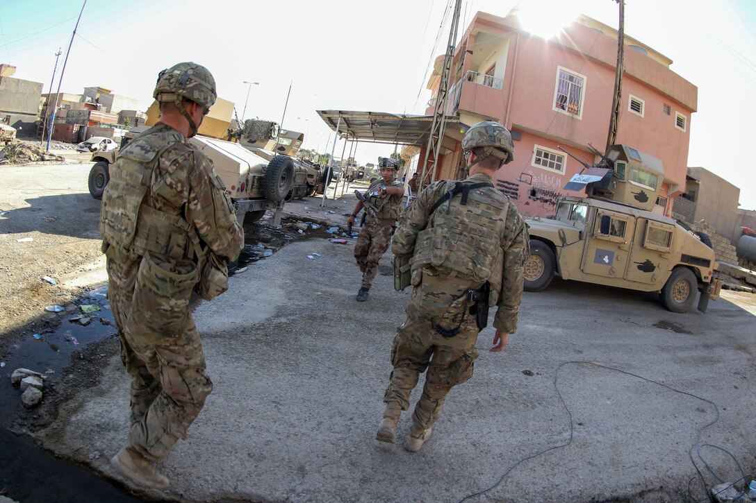 U.S. and Iraqi soldiers greet each other in a neighborhood liberated from the Islamic State of Iraq and Syria in Mosul, Iraq, June 8, 2017. The U.S. soldiers, deployed in support of Combined Joint Task Force Operation Inherent Resolve and assigned to 2nd Brigade Combat Team, 82nd Airborne Division, enable their Iraqi partners through the advise and assist mission, contributing planning, intelligence collection and analysis, force protection and precision fires to achieve the military defeat of ISIS. Army photo by Staff Sgt. Jason Hull
