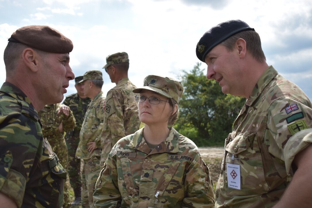 (Left to right) Lt. Col. Nicolae Acasandrei, operations officer at Joint National Training Center; Lt. Col. Nicole Davis, 926th Engineer Brigade executive officer; and Lt. Col. Scott Spencer, commander of the Royal Monmouthshire Royal Engineers (Militia) discuss the integration of forces at Resolute Castle 2017. U.S., U.K., and Romanian engineers are building a non-standard live-fire range and a breaching and demolition range. Resolute Castle is an exercise strengthening the NATO alliance and enhancing its capacity for joint training and response to threats within the region.