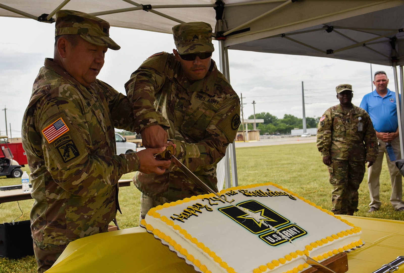 Col. Yee C. Hang, director, DLA Land and Maritime Land Supplier Opperstations, cuts the Army birthday cake on June 14 with Sgt Diaz at Defense Supply Center Columbus.  The cake ceremony is a long standing Army tradition where the soldier with longest time in service cuts the cake with the soldier with the least amount of time in service using the ceremonial military saber.