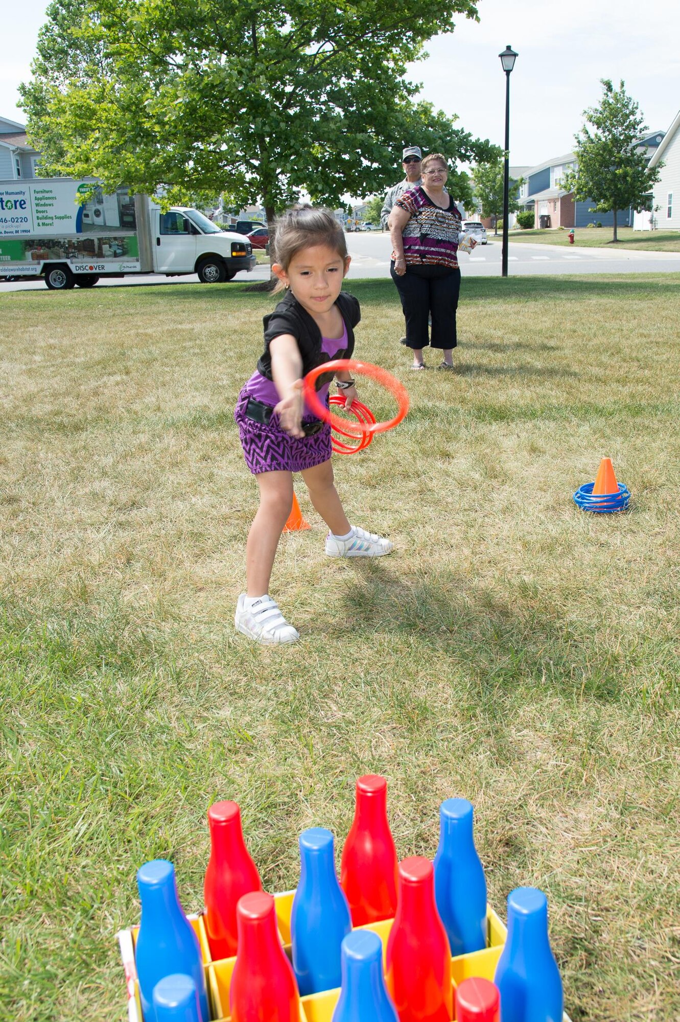 Elena Revilla, daughter of MSgt. Jesus Revilla, 436th Civil Engineering Squadron infrastructure superintendent, plays a ring toss game during the Hurricane Block Party June 15, 2017, in Eagle Heights family housing on  Dover Air Force Base, Del. The block party had children’s activities including games and a bouncy house. (U.S. Air Force photo by Mauricio Campino)