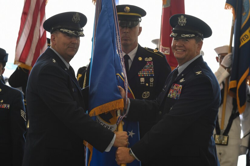Maj. General Christopher Bence, United States Air Force Expeditionary Center commander, facilitates the passing of the guidon to Col. Neil Richardson, Joint Base McGuire-Dix-Lakehurst and 87th Air Base Wing commander, during a change of command ceremony here, June 19, 2017. A typical tour of command at the joint base is two years in length.