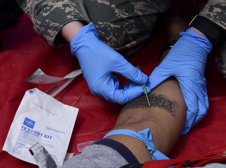 U.S. Air Force Senior Airman Lauren Pape, 110th Bomb Squadron flight and operational medical technician, insert an IV into a volunteer during an exercise at Royal Air Force Fairford, U.K., June 13, 2017. Four medical Airmen from the 110th Bomb Squadron and the 37th Expeditionary Bomb Squadron serve roughly 800 Airmen at RAF Fairford in support of bomber assurance and deterrence missions. (U.S. Air Force photo by Airman 1st Class Randahl J. Jenson)