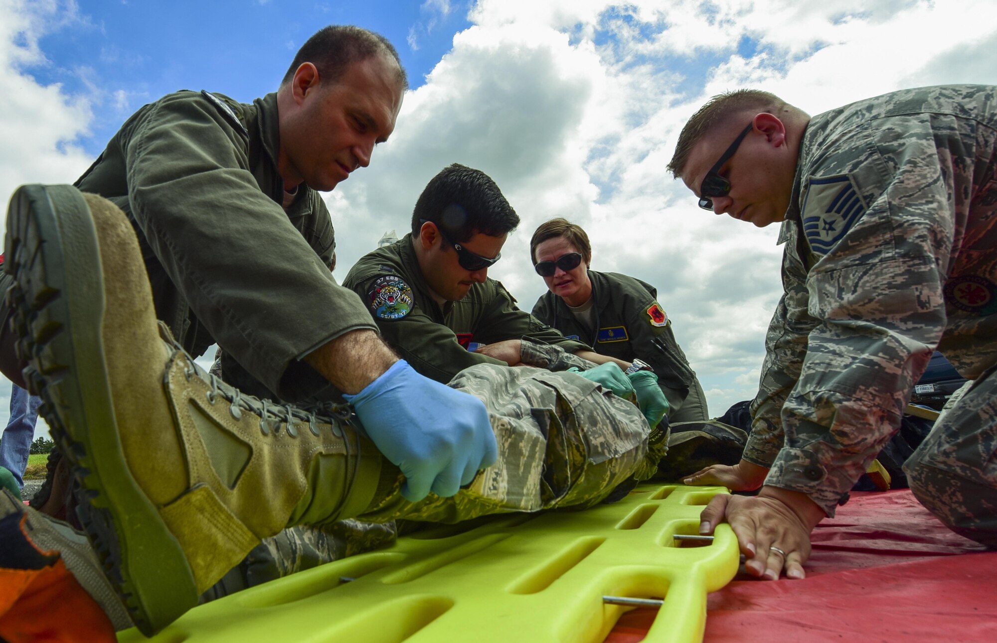 U.S. Air Force medical personnel from the 110th Bomb Squadron and the 37th Expeditionary Bomb Squadron, and firefighters, roll a volunteer onto a gurney during an exercise at Royal Air Force Fairford, U.K., June 13, 2017. Exercises involving multiple departments provide opportunities to increase interoperability and readiness. (U.S. Air Force photo by Airman 1st Class Randahl J. Jenson)