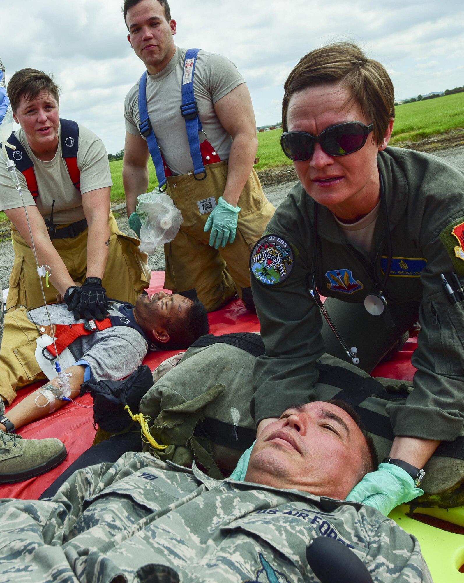 U.S. Air Force Tech. Sgt. Nicole Henry (far right), 37th Expeditionary Bomb Squadron flight, and an operational medical technician, support the head of a volunteer during a medical exercise at Royal Air Force Fairford, U.K., June 13, 2017. Four medical Airmen from the 110th Bomb Squadron and the 37th Expeditionary Bomb Squadron serve roughly 800 Airmen at RAF Fairford in support of bomber assurance missions. (U.S. Air Force photo by Airman 1st Class Randahl J. Jenson)
