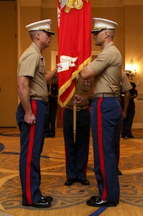 Major David P. Tumanjan, commanding officer of Recruiting Station Fort Lauderdale, presents the unit colors to Maj. Marcus D. Gillett during a change of command ceremony held at the Double Tree Hotel in Sunrise, Florida, June, 9, 2017. By accepting the colors from Tumanjan, Gillett accepted command of the recruiting station. (U.S. Marine Corps Photo by Sgt. Andy J. Orozco)