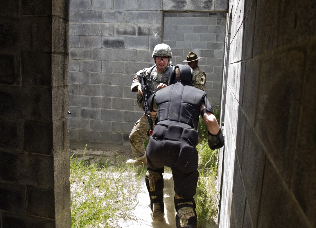 An instructor at the XVIII Airborne Corps Combatives School rounds a corner and charges Spc. Wantae Seong, a carpentry and masonry specialist representing 412th Theater Engineer Command during the Combat Skills Testing Lanes at the 2017 U.S. Army Reserve Best Warrior Competition at Fort Bragg, N.C. June 14. This year’s Best Warrior Competition will determine the top noncommissioned officer and junior enlisted Soldier who will represent the U.S. Army Reserve in the Department of the Army Best Warrior Competition later this year at Fort A.P. Hill, Va. (U.S. Army Reserve photo by Sgt. William A. Parsons) (Released)