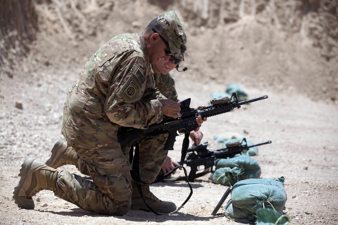 Army Sgt. Kurt Komyati, rear, and Army Command Sgt. Maj. Randolph Delapena clear their M4 rifles at a range at Qayyarah West Airfield, Iraq, June 10, 2017. The soldiers are assigned to the 2nd Brigade Combat Team, 82nd Airborne Division. Army photo by Cpl. Rachel Diehm
