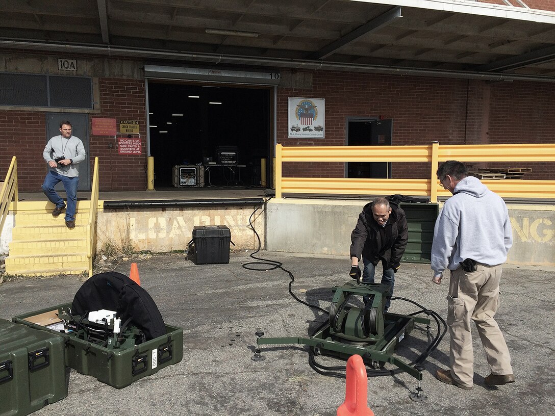 DLA Information Operations Contingency Information Technology Team members Tony Johnson, Paul Chamnan, and John Wolk set up a satellite antenna outside Building 1331 to provide network and Distribution Standard System services in response to the EF3 tornado that touched down at DLA Distribution Albany, Georgia.