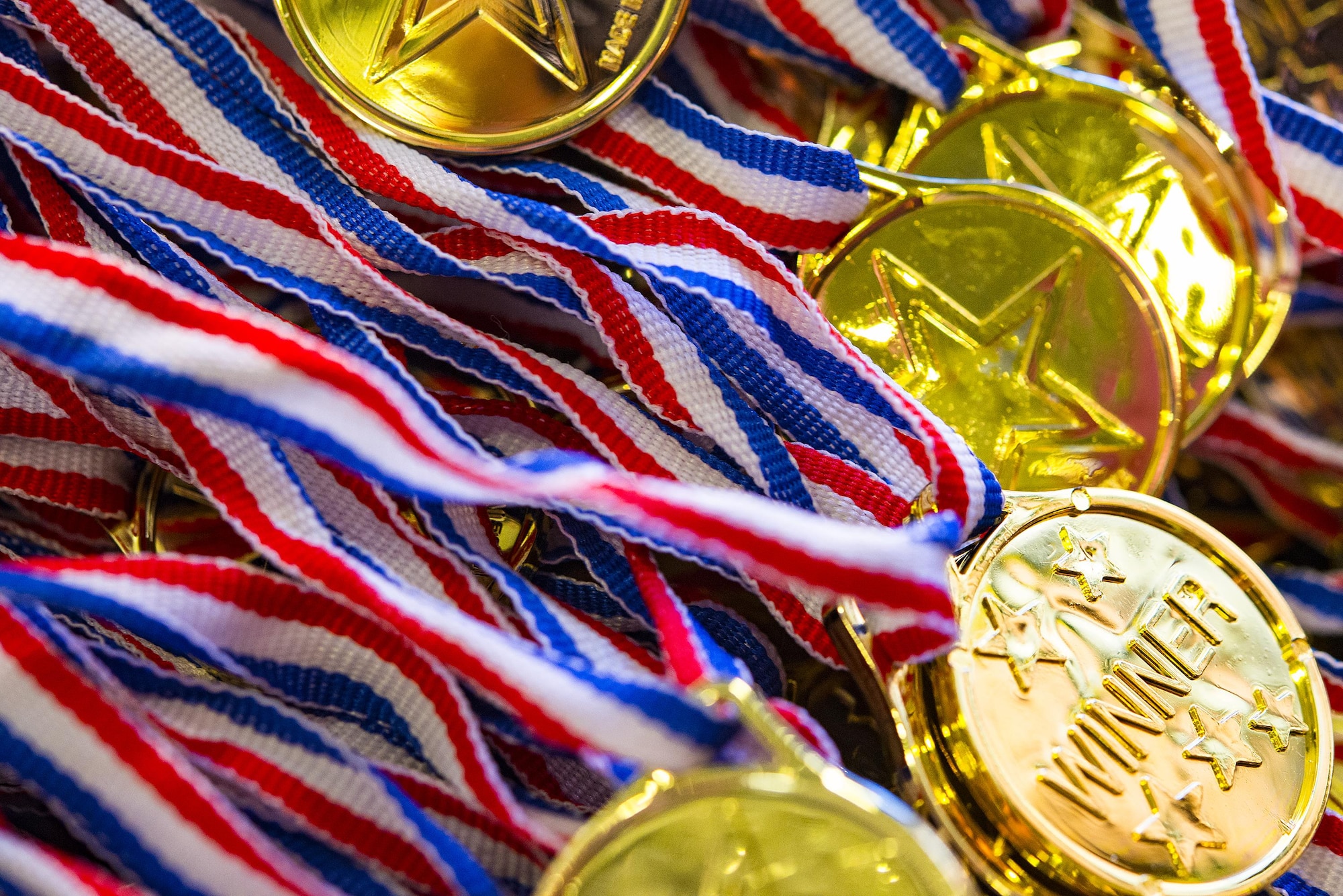 Medals rest in a pile in the Youth Center during Olympic Week, June 15, 2017, at Moody Air Force Base, Ga. The goal of Olympic Week was to promote unity and healthy lifestyles. (U.S. Air Force Photo by Airman 1st Class Erick Requadt)