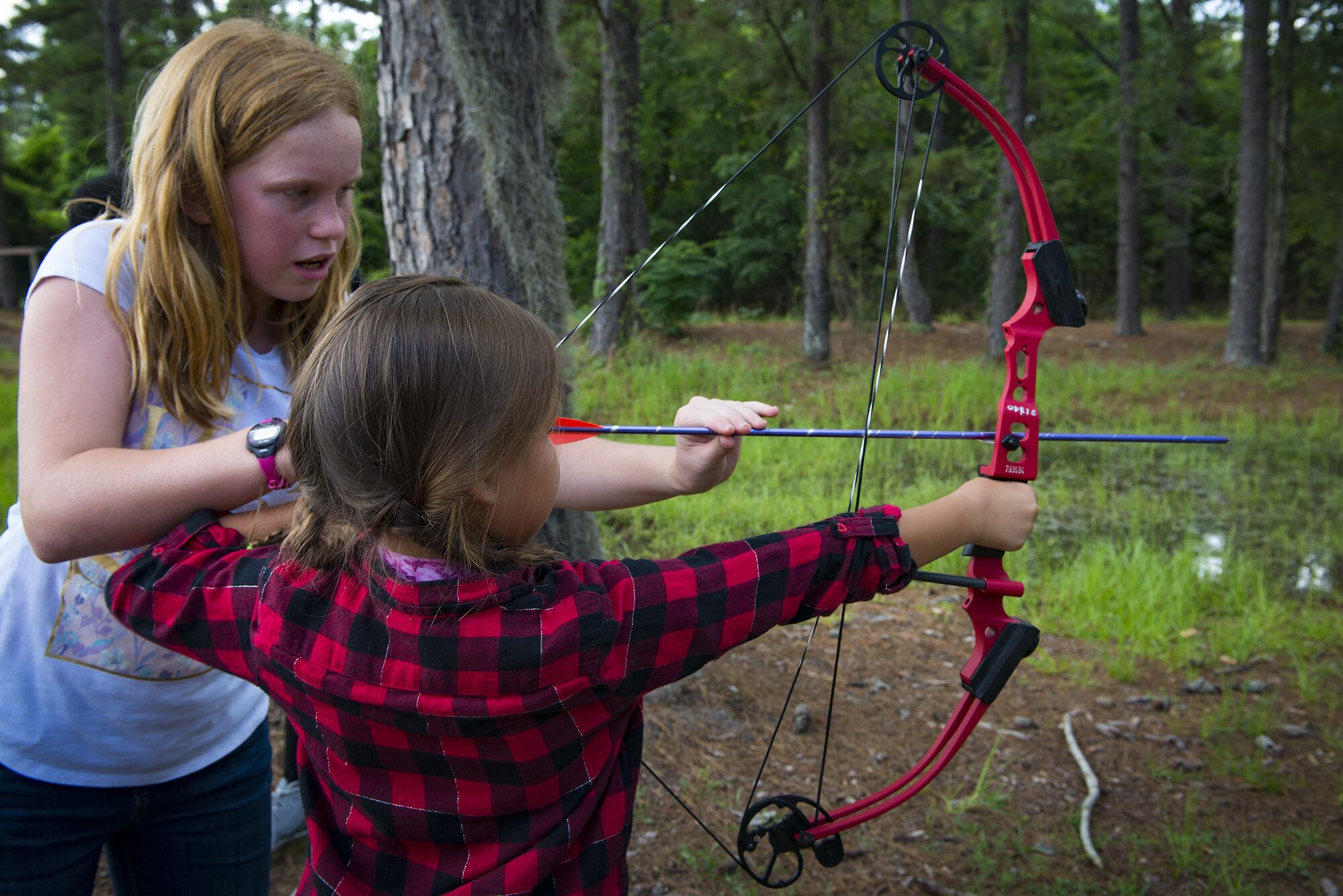 Emma, daughter of Senior Master Sgt. Anna Keck, 23d Communications Squadron superintendent, gives Kairi, daughter of Tech. Sgt. Anthony Guevara, some final advise before she fires her bow at the archery range during Olympic Week, June 14, 2017, at Moody Air Force Base, Ga. Archery was part of the Youth Center’s annual Olympic Week, with the goal of promoting unity and healthy lifestyles. (U.S. Air Force Photo by Airman 1st Class Erick Requadt) 