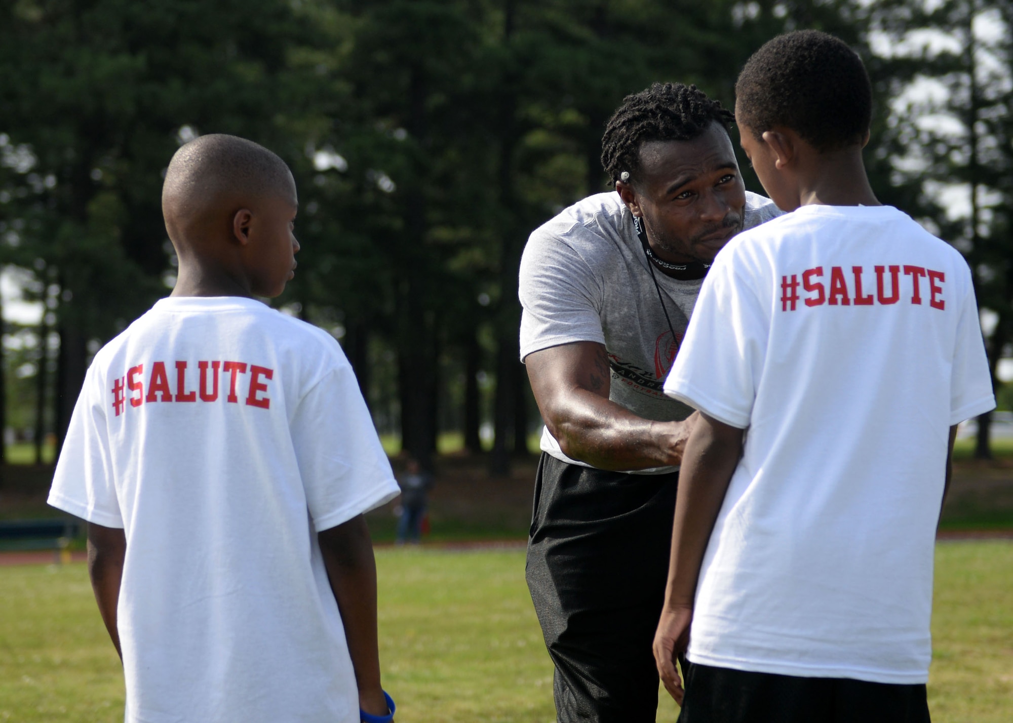 A volunteer at the Proctor & Gamble Andre Roberts Football ProCamp teaches military children different football drills June 16, 2017, at Little Rock Air Force Base, Arkansas. Children who attended the camp had the opportunity to learn different football skills from Andres Roberts, an Atlanta Falcons wide receiver and former military child. (U.S. Air Force photo by Airman 1st Class Codie Collins)
