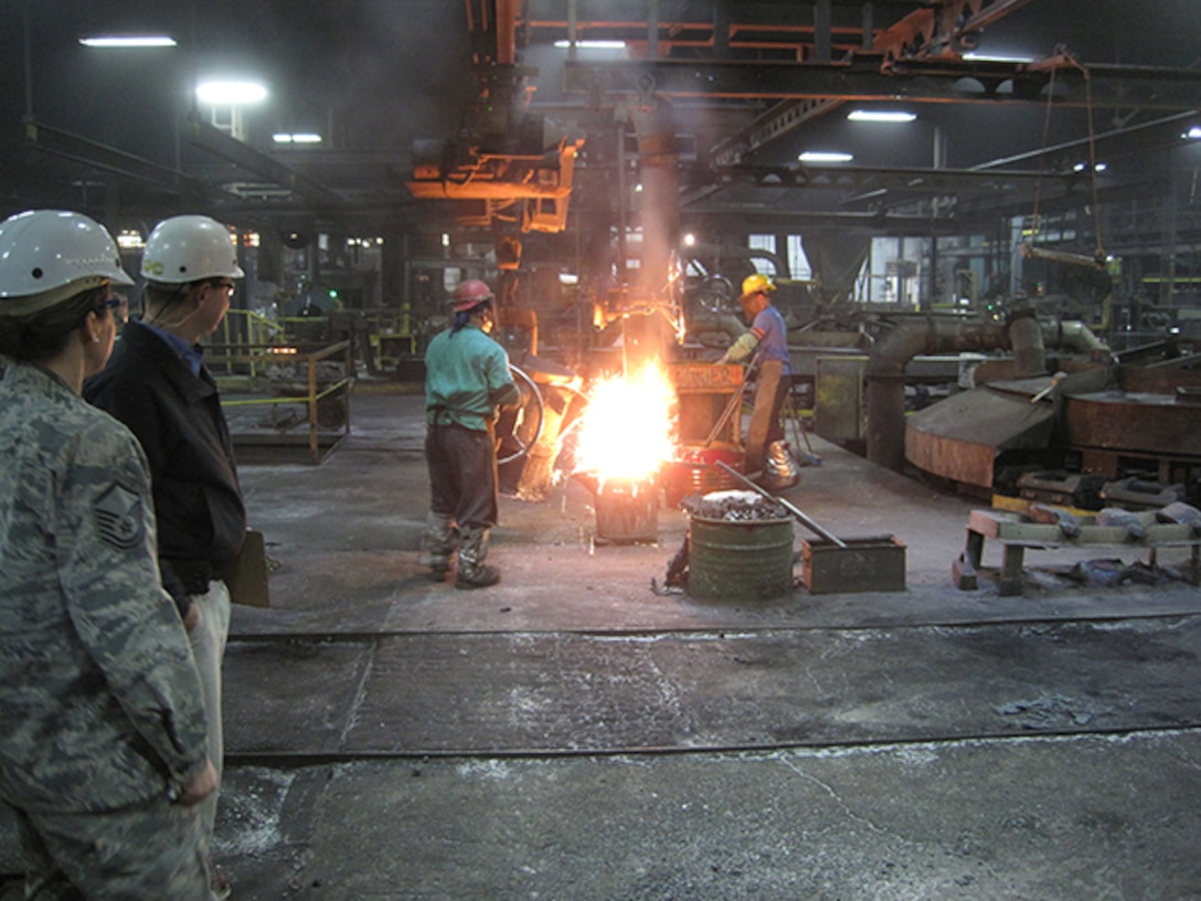 DLA Aviation’s Air Force Master Sgt. Gabriela Camarillo, left, watches casting at the Buck Company foundry, Quarryville, Pennsylvania.