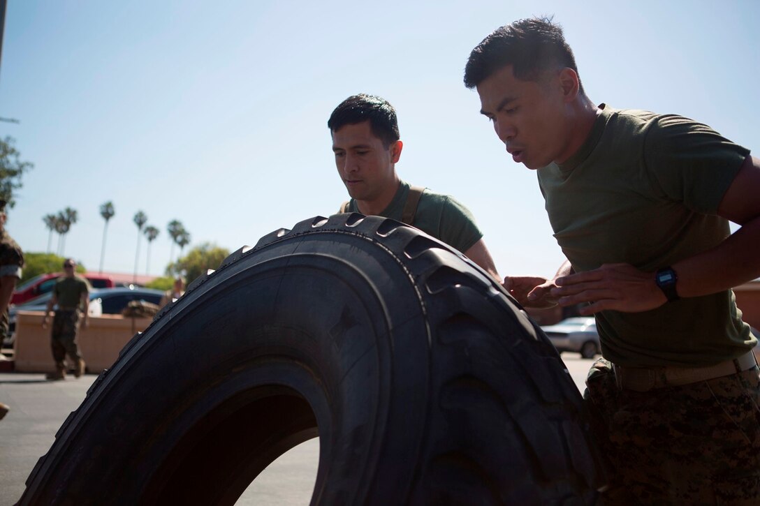 U.S. Navy Petty Officer Third  Class Julian Eledia, Hugo Reaendez, Corpsmen with 1st Medical Battalion, 1st Marine Logistics Group, participate in a tire flip contest during the North County Corpsman Cup on Camp Pendleton, Calif., June 16, 2017. The North County Corpsman Cup is designed to test the knowledge, physical readiness and teamwork of each participating sailor while promoting esprit de corps among the Hospital Corpsman community. (U.S. Marine Corps photo by Lance Cpl. Joseph Sorci)