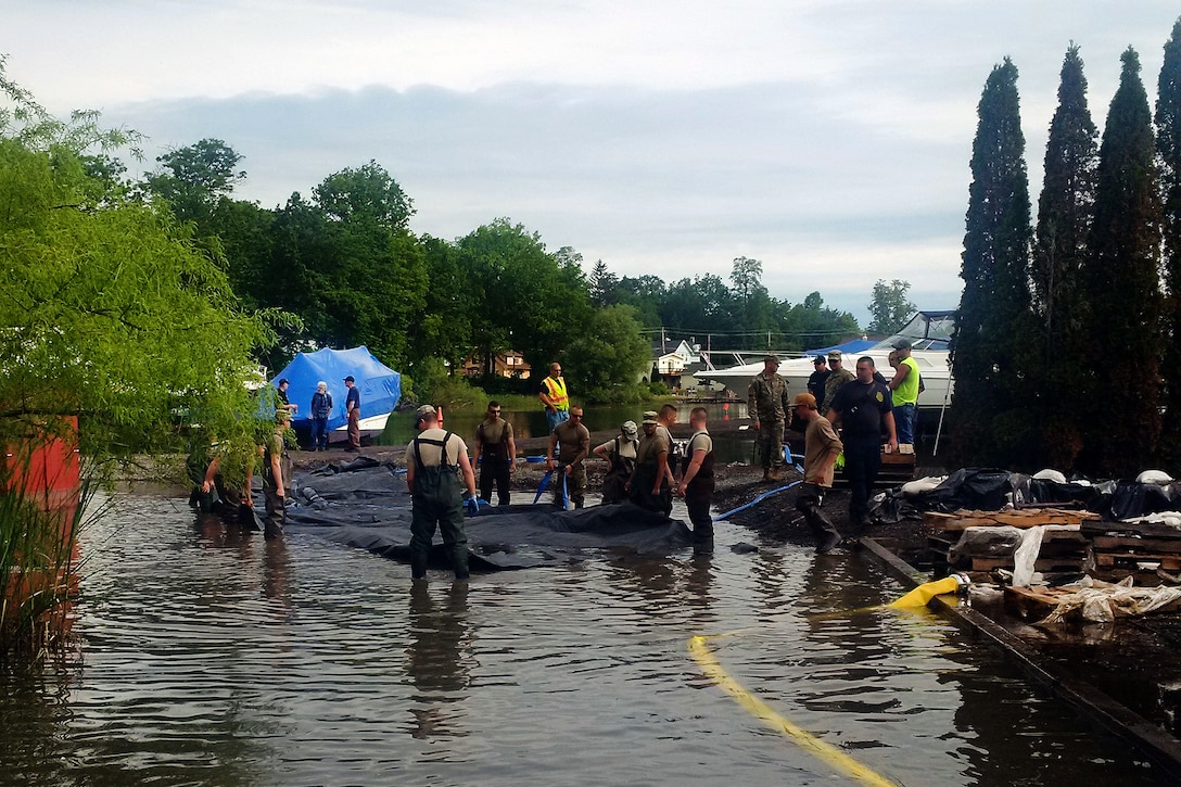New York Army National Guardsmen and first responders deploy an AquaDam, a water-filled cofferdam, to control Lake Ontario’s high water levels at Sodus Point, N.Y., June 13, 2017. New York Army National Guard photo by Brig. Gen. Patrick Center