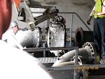 Workers remove a 14-inch double-block and bleed valve as part of DLA’s closure of Defense Fuel Support Point San Pedro.