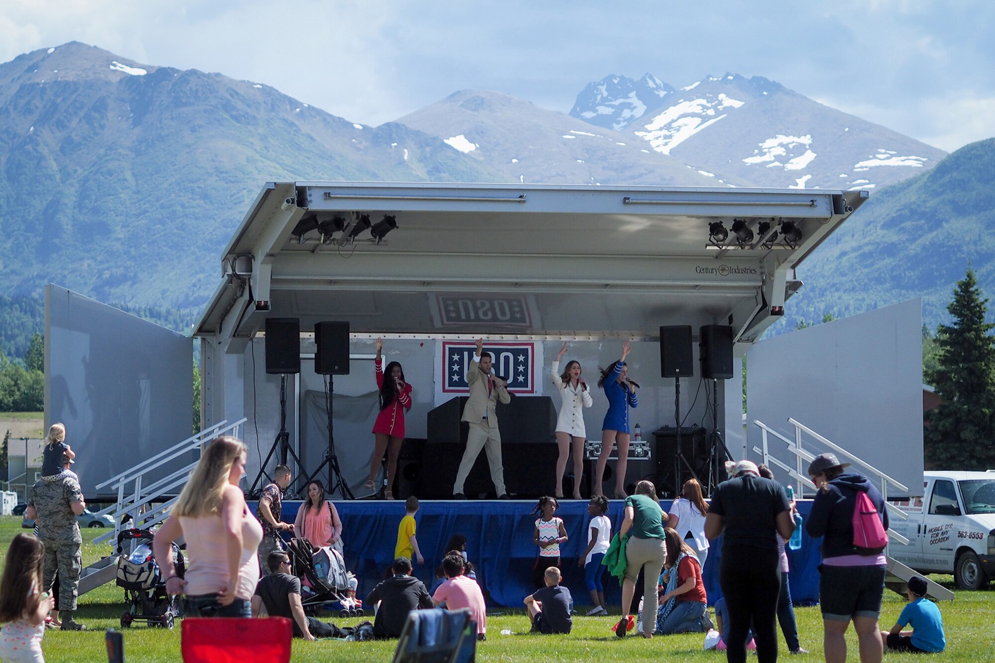 United Service Organizations singers perform on stage as service members, dependents, and Department of Defense civilians attend the Military Appreciation Week picnic at the Joint Base Elmendorf-Richardson, Alaska, Buckner Fitness Center fields June 16, 2017. Several organizations came together to provide a variety of family-fun activities such as competitive sporting events for the adults, face painting and bouncy houses for the children in addition to the Anchorage Chamber of Commerce-provided food and music during the annual event.