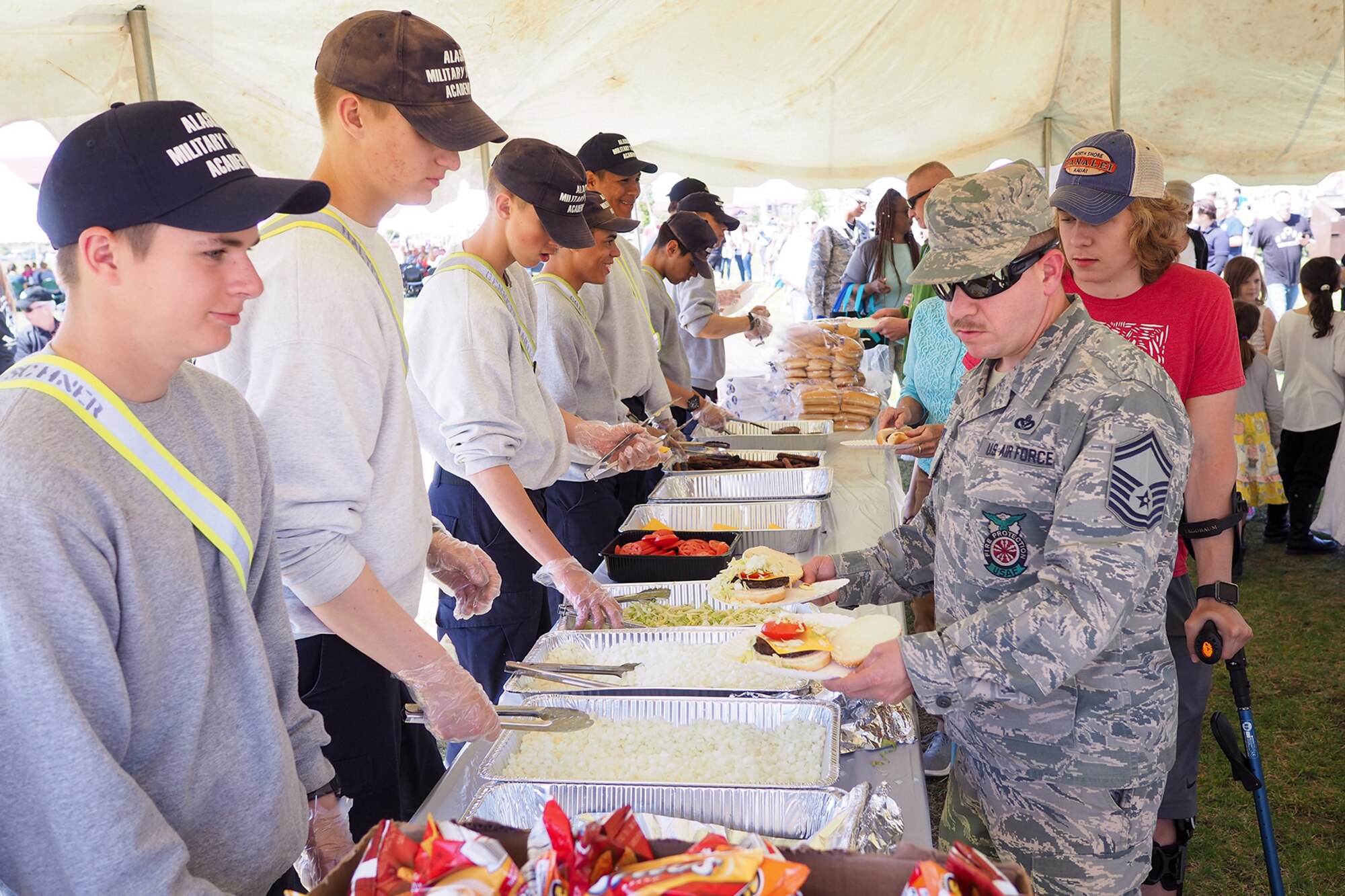 Air Force Senior Master Sgt. John Smith, a 176th Civil Engineer Squadron firefighter, walks through a food line at the Military Appreciation Week picnic at the Joint Base Elmendorf-Richardson, Alaska, Buckner Fitness Center fields June 16, 2017. Several organizations came together to provide a variety of family-fun activities such as competitive sporting events for the adults, face painting and bouncy houses for the children in addition to the Anchorage Chamber of Commerce-provided food and music during the annual event.