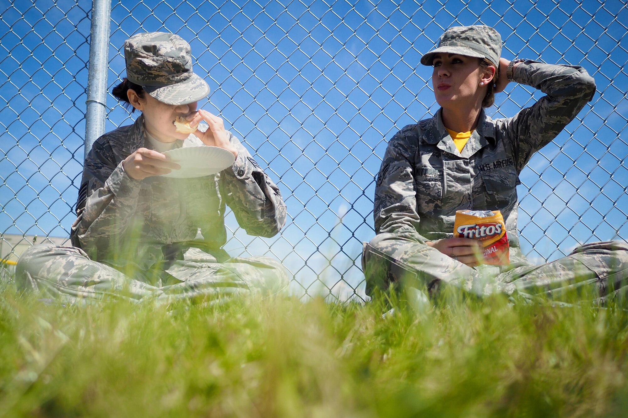 Air Force Staff Sgt. Ana Escobar-Willacey, and Airman 1st Class Kimberly Mott, both assigned to the 673rd Medical Group, enjoy food at the Military Appreciation Week picnic at the Joint Base Elmendorf-Richardson, Alaska, Buckner Fitness Center fields June 16, 2017. Several organizations came together to provide a variety of family-fun activities such as competitive sporting events for the adults, face painting and bouncy houses for the children in addition to the Anchorage Chamber of Commerce-provided food and music during the annual event.