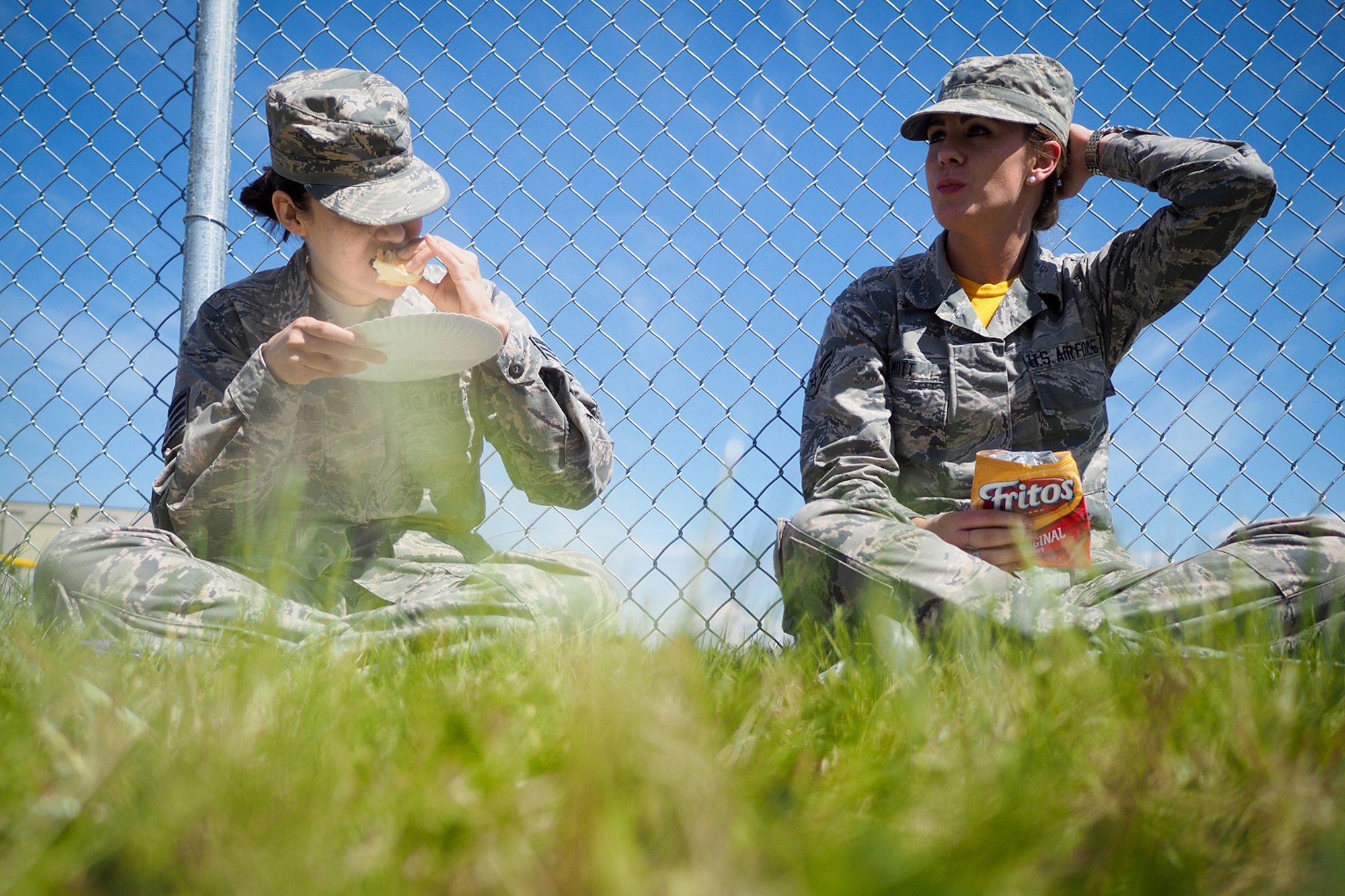 Air Force Staff Sgt. Ana Escobar-Willacey, and Airman 1st Class Kimberly Mott, both assigned to the 673rd Medical Group, enjoy food at the Military Appreciation Week picnic at the Joint Base Elmendorf-Richardson, Alaska, Buckner Fitness Center fields June 16, 2017. Several organizations came together to provide a variety of family-fun activities such as competitive sporting events for the adults, face painting and bouncy houses for the children in addition to the Anchorage Chamber of Commerce-provided food and music during the annual event.