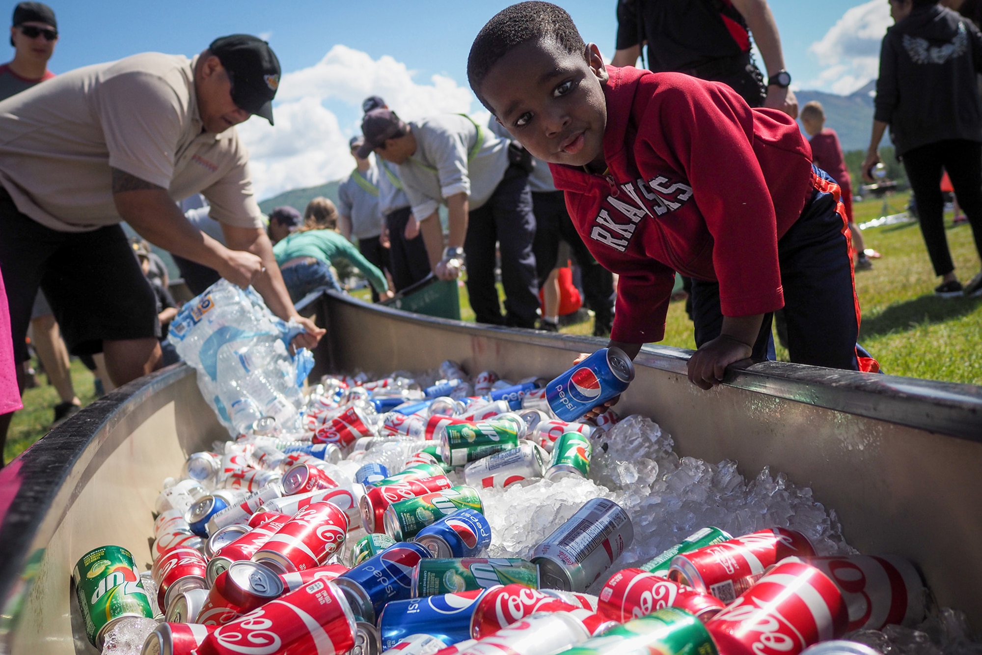 Zachary Sharp takes a can of soda from a canoe filled with ice and soft drinks as service members, dependents, and Department of Defense civilians attend the Military Appreciation Week picnic at the Joint Base Elmendorf-Richardson, Alaska, Buckner Fitness Center fields June 16, 2017. Several organizations came together to provide a variety of family-fun activities such as competitive sporting events for the adults, face painting and bouncy houses for the children in addition to the Anchorage Chamber of Commerce-provided food and music during the annual event.