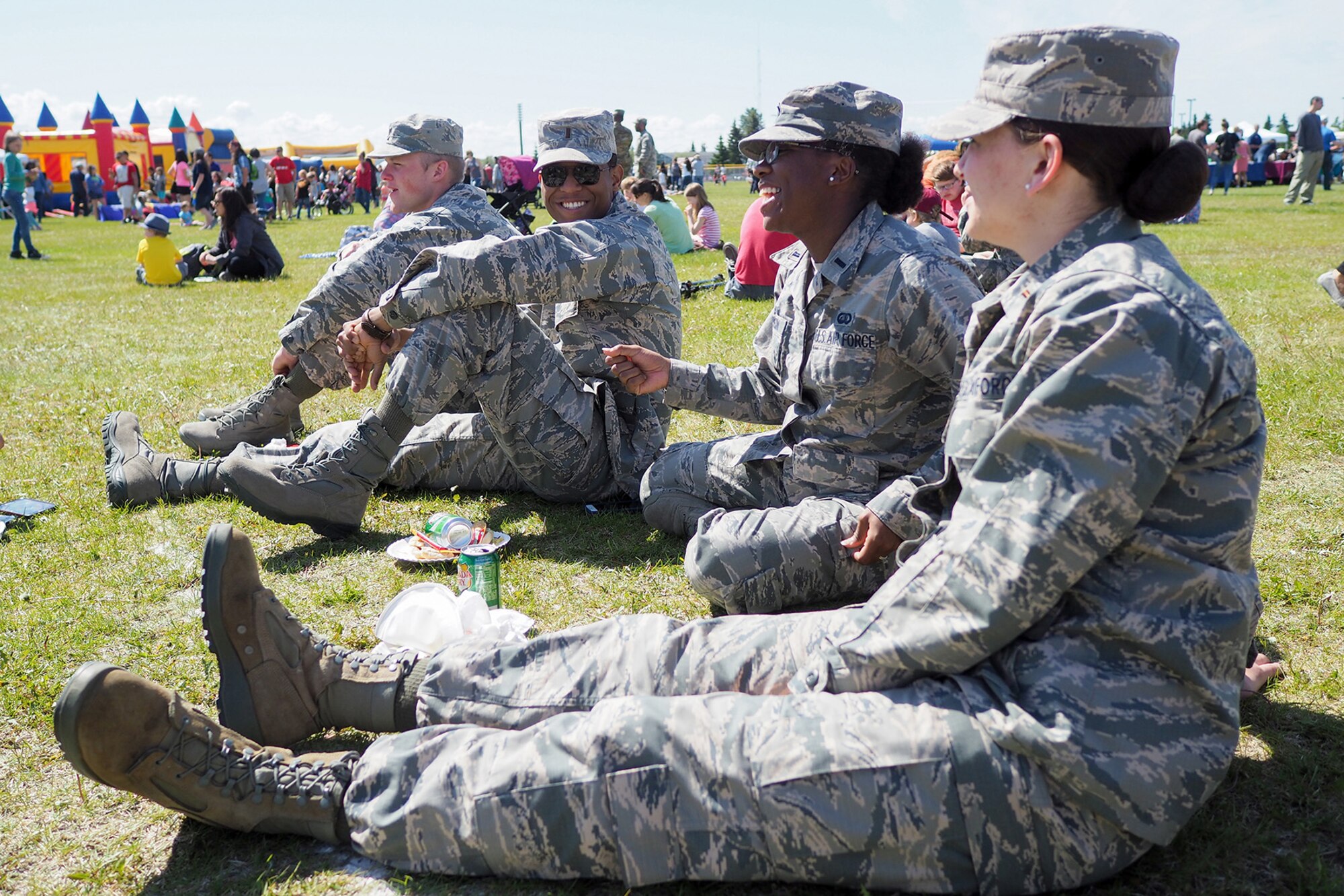 Air Force Airmen share a laugh as service members, dependents, and Department of Defense civilians attend the Military Appreciation Week picnic at the Joint Base Elmendorf-Richardson, Alaska, Buckner Fitness Center fields June 16, 2017. Several organizations came together to provide a variety of family-fun activities such as competitive sporting events for the adults, face painting and bouncy houses for the children in addition to the Anchorage Chamber of Commerce-provided food and music during the annual event.