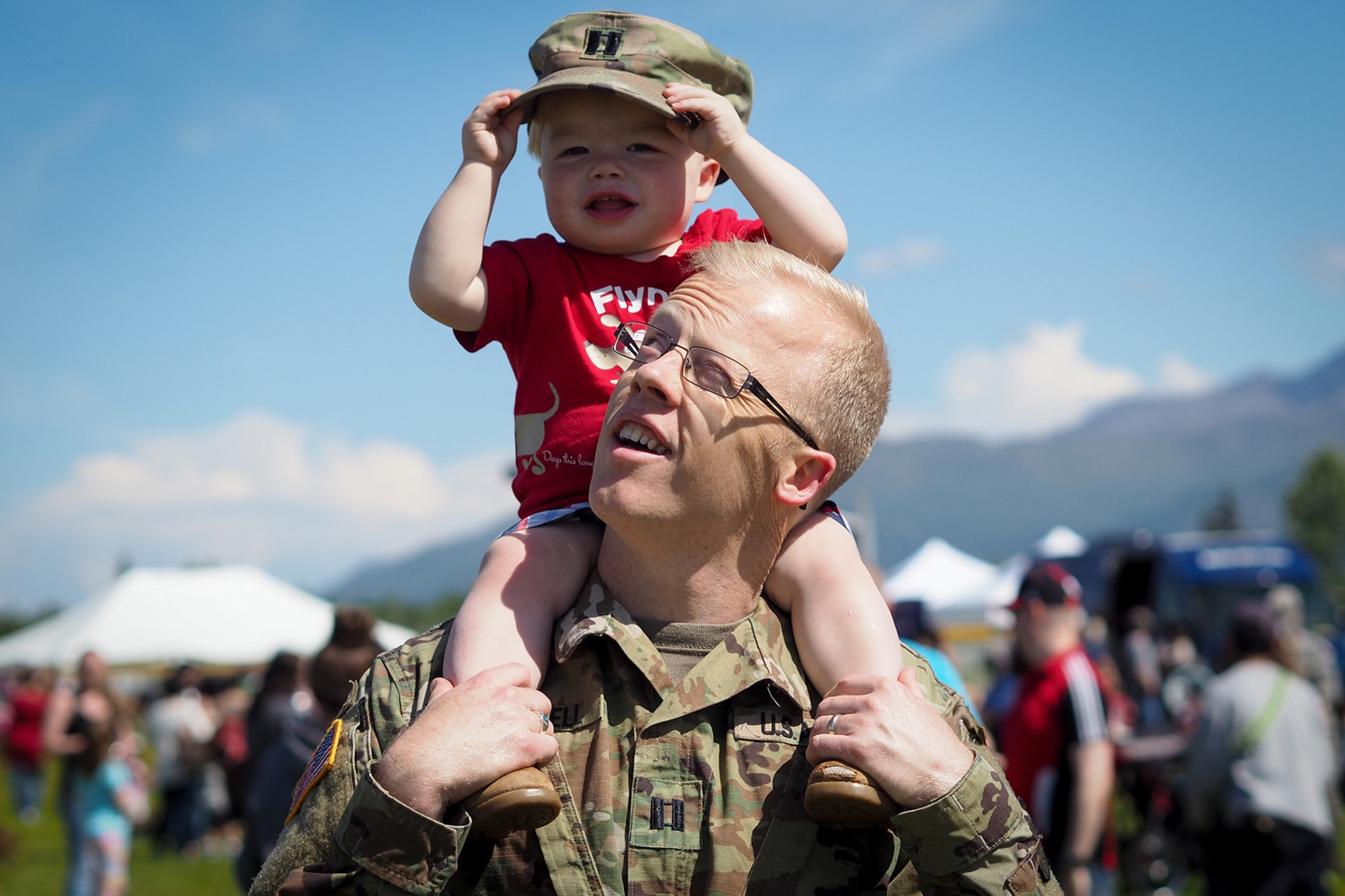 Army Capt. Ben Russell, carries his son Todd, 18-months-old, on his shoulders at the annual Military Appreciation Week picnic at the Joint Base Elmendorf-Richardson, Alaska, Buckner Fitness Center fields June 16, 2017. Several organizations came together to provide a variety of family-fun activities such as competitive sporting events for the adults, face painting and bouncy houses for the children in addition to the Anchorage Chamber of Commerce-provided food and music during the annual event.