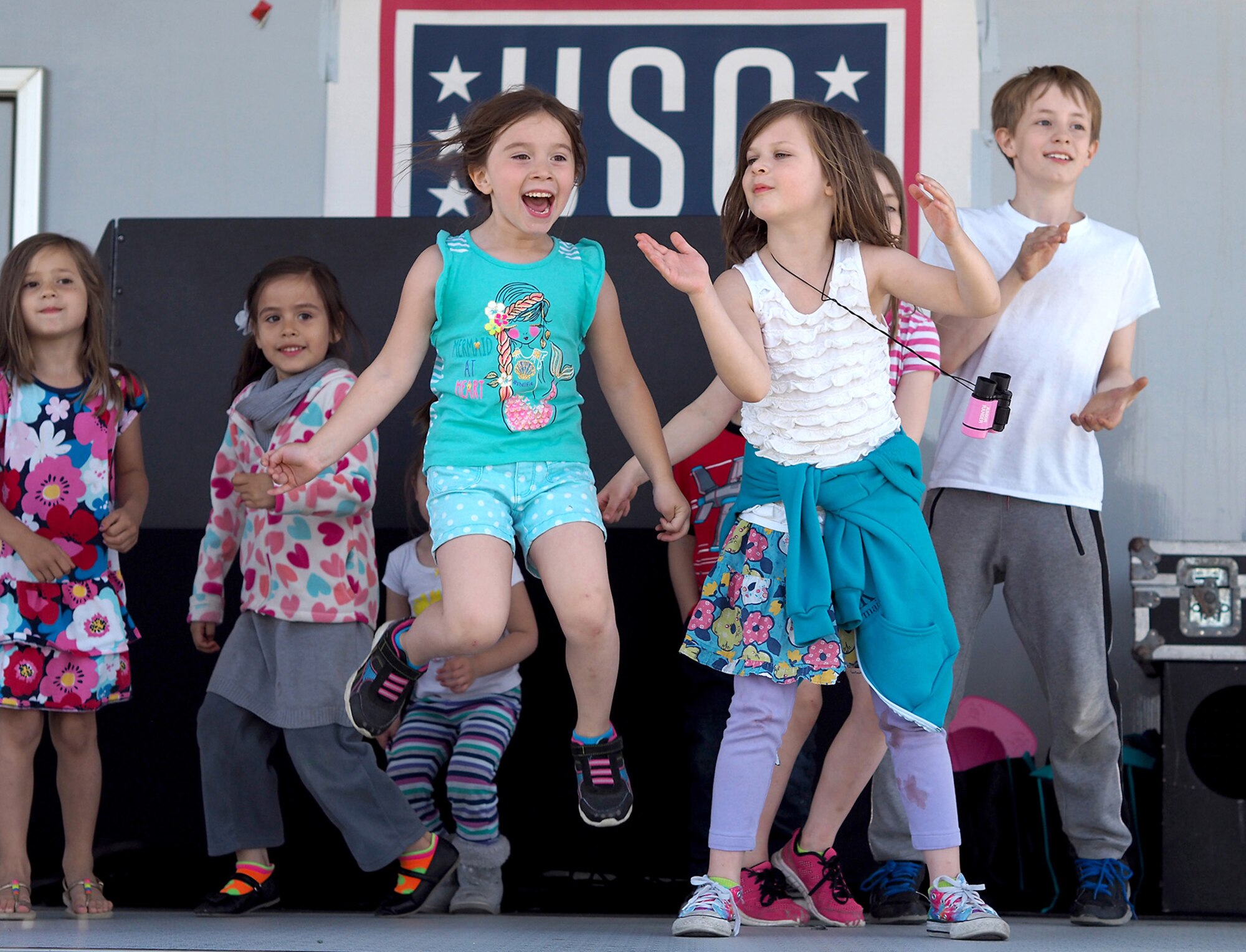 Children of military personnel stationed at Joint Base Elmendorf-Richardson, Alaska, dance on the United Service Organizations’ stage during the Military Appreciation Week picnic for service members, dependents, and Department of Defense civilians at the JBER Buckner Fitness Center fields June 16, 2017. Several organizations came together to provide a variety of family-fun activities such as competitive sporting events for the adults, face painting and bouncy houses for the children in addition to the Anchorage Chamber of Commerce-provided food and music during the annual event.