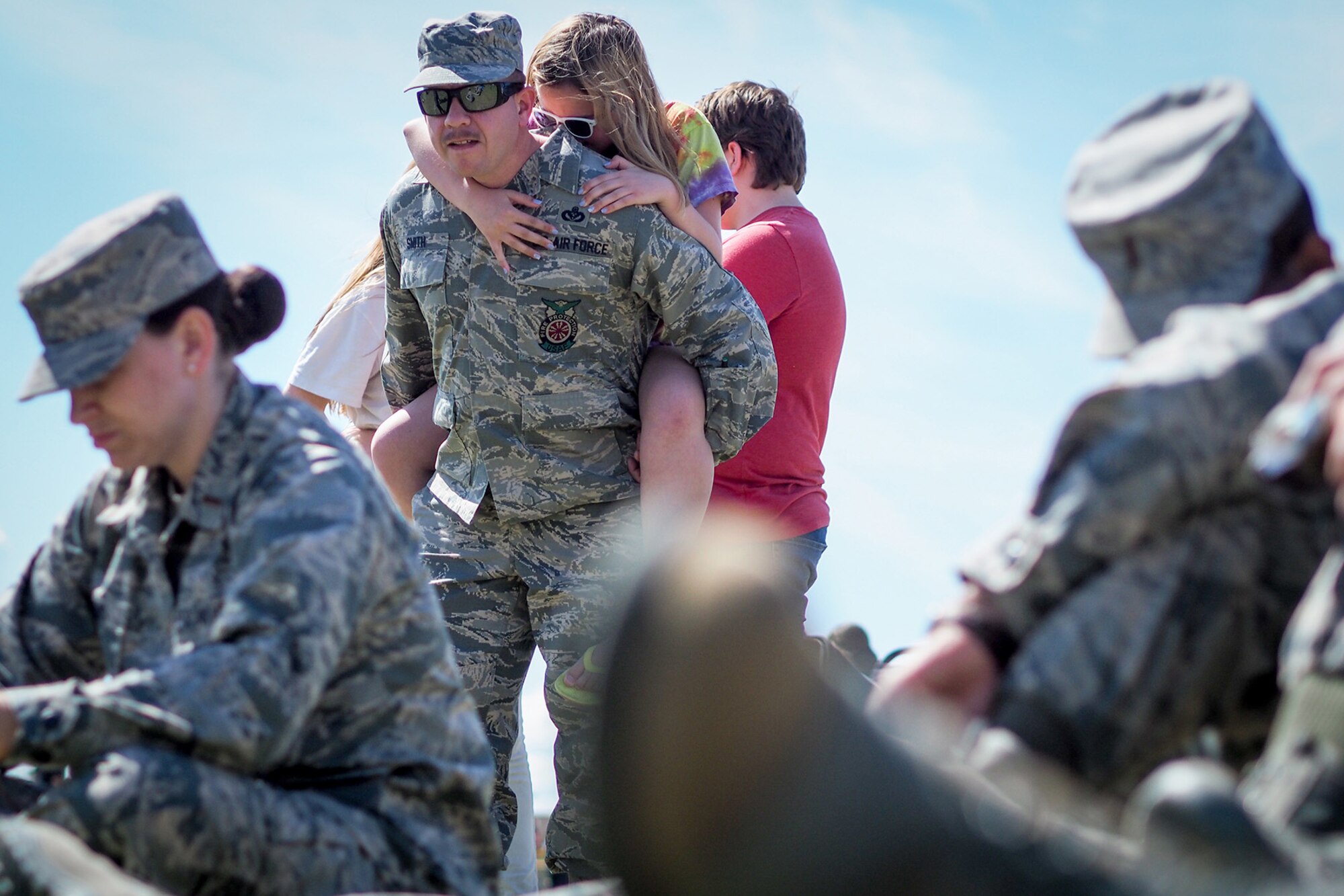 Aubrey Smith, 11, hugs her father Air Force Senior Master Sgt. John Smith, a 176th Civil Engineer Squadron firefighter, as service members, dependents, and Department of Defense civilians attend the Military Appreciation Week picnic at the Joint Base Elmendorf-Richardson, Alaska, Buckner Fitness Center fields June 16, 2017. Several organizations came together to provide a variety of family-fun activities such as competitive sporting events for the adults, face painting and bouncy houses for the children in addition to the Anchorage Chamber of Commerce-provided food and music during the annual event.