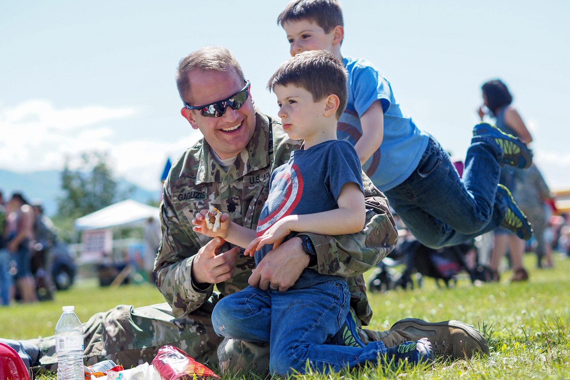 Army Lt. Col. Marc Gaguzis, assigned to Headquarters and Headquarters Detachment, U.S. Army Alaska, holds his son Alex, 4, as his other son Jacob, 4, jumps on his back while service members, dependents, and Department of Defense civilians attend the Military Appreciation Week picnic at the Joint Base Elmendorf-Richardson, Alaska, Buckner Fitness Center fields June 16, 2017. Several organizations came together to provide a variety of family-fun activities such as competitive sporting events for the adults, face painting and bouncy houses for the children in addition to the Anchorage Chamber of Commerce-provided food and music during the annual event.