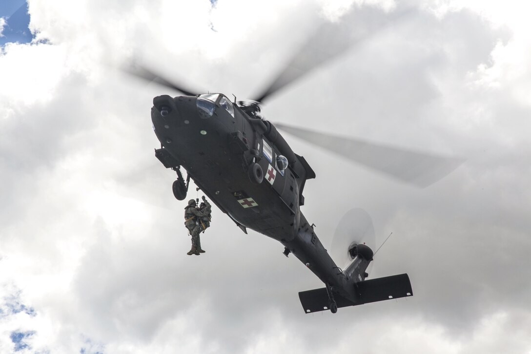 Soldiers hoist a simulated wounded soldier into an HH60-M Medevac Blackhawk during the Golden Coyote training exercise in Belle Fourche Reservoir, S.D., June 19, 2017. The scenario-driven exercise enables commanders to focus on mission essential task requirements, warrior tasks and battle drills. The soldiers are assigned to Company C, 1st Battalion, 189th Aviation Regiment, South Dakota Army National Guard. Army photo by Spc. Mitchell Murphy
