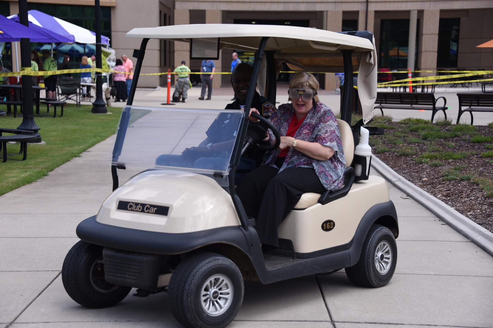 PETERSON AIR FORCE BASE, Colo. - Officer Curtis Summerville, Alabama Department of Public Safety public information officer, guides Sylvia Martin, executive assistant, U.S. Army Space and Missile Defense Command/Army Forces Strategic Command, on the drunk goggles course during the Missile Defense Agency and SMDC's ninth annual Joint Safety Awareness Day and Health Expo to promote safety awareness June 8 at the Von Braun Complex on Redstone Arsenal, Alabama. The purpose of the joint venue is to promote safety awareness and to minimize the risk of unintentional death, injury or damage caused by mishaps, promote proactive safety measures and recognize June as National Safety Month. (U.S. Army photo by Carrie David)