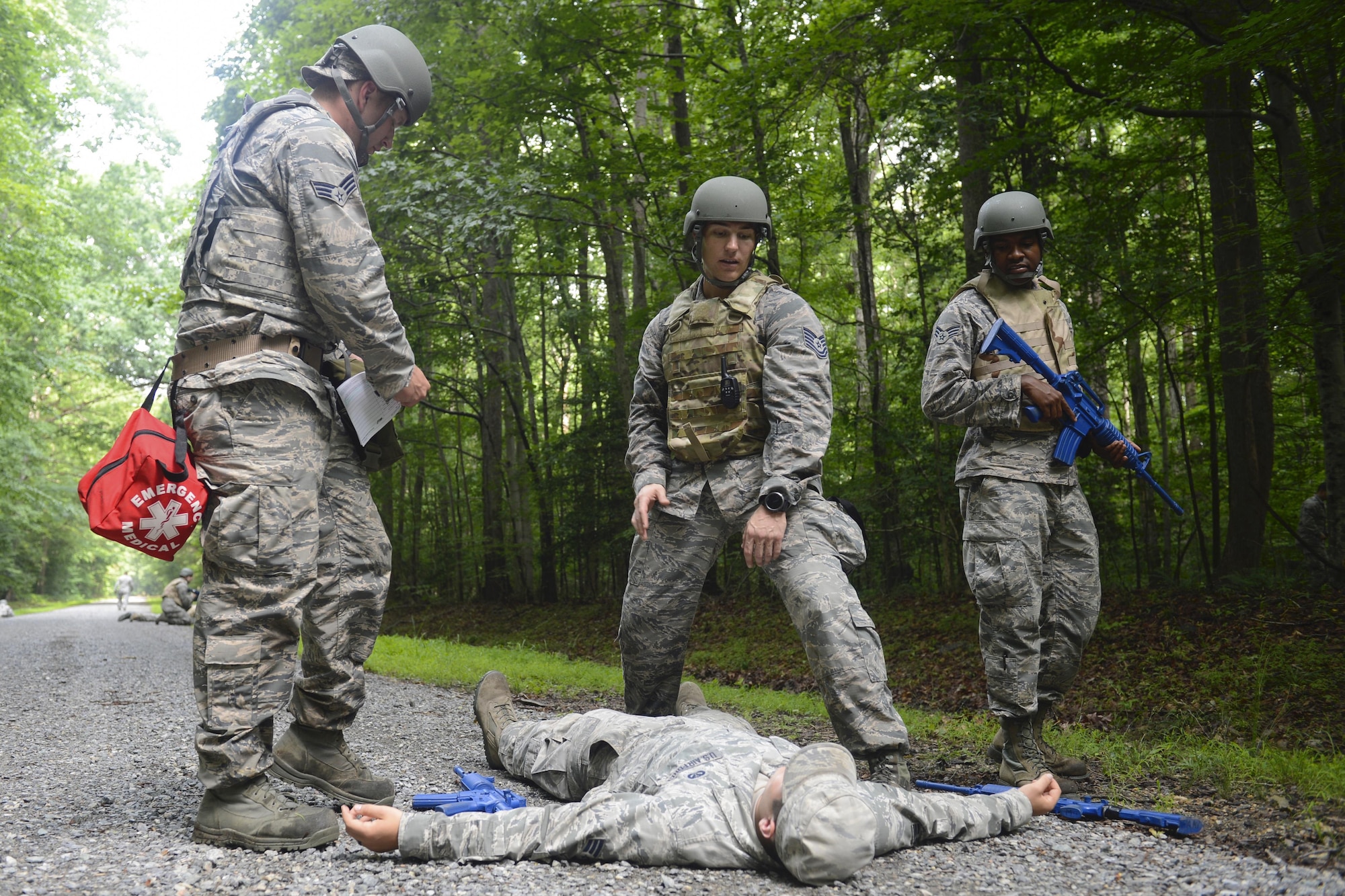 U.S. Air Force Airmen assigned to the 633rd Civil Engineer Squadron practice self-aid and buddy care on an injured Airman during Prime Base Engineer Emergency Force convoy training at Joint Base Langley-Eustis, Va., June 15, 2017. The Airmen learned how to call in aerial support to transport an injured team member during hostile situations. (U.S. Air Force photo/Airman 1st Class Kaylee Dubois)