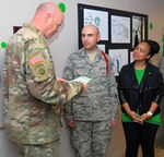 Col. Mark A. Lee (left), 502nd Air Base Wing vice commander, and guest speaker Marlo Bearden (right) present Airman 1st Class Al Qaisi (middle) the first-ever 59th Training Group “Green Dot Spotlight” award during the unveiling ceremony. 