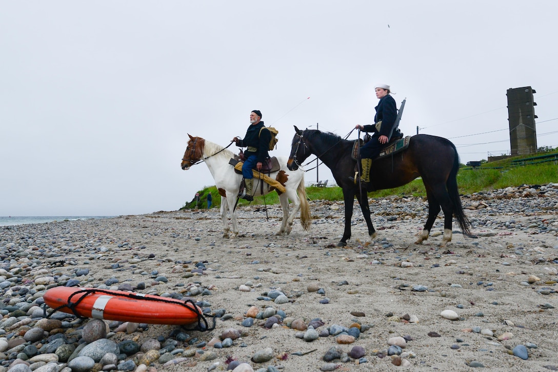 Wayne Ormsbee, a Coast Guard employee, and his daughter Coast Guard Petty Officer 2nd Class Keisha Kerr, reenact World War II Coast Guard mounted patrols at Fourth Cliff Recreation Area in Humarock, Massachusetts, June 5, 2017. 