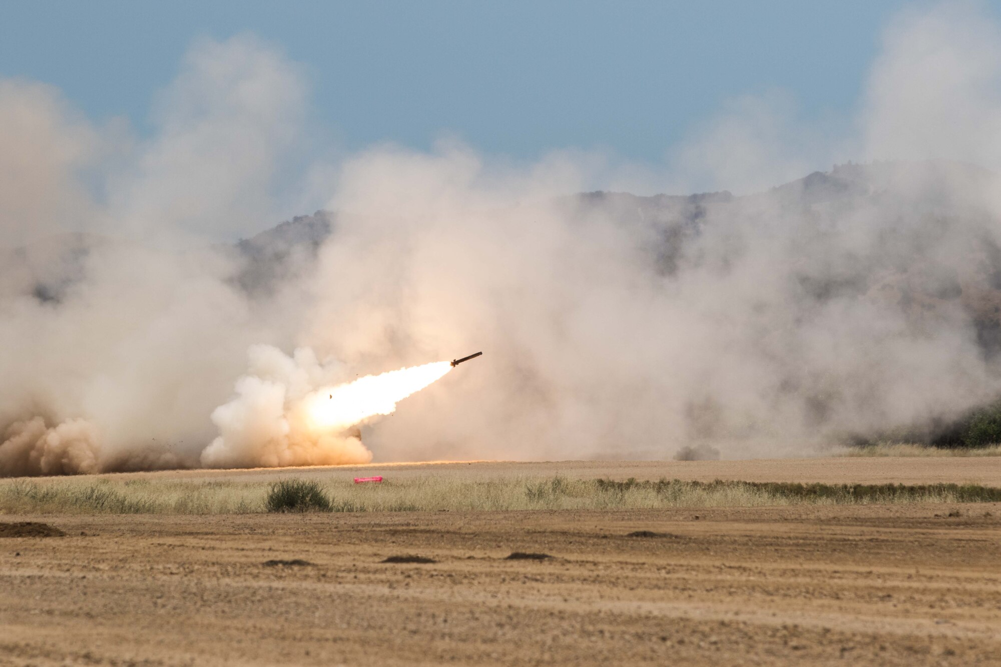 A High Mobility Artillery Rocket System crew from A Battery, 1st Battalion, 94th Field Artillery Regiment, 17th Field Artillery Brigade fires a rocket off of the Fort Hunter Liggett, Calif. dirt landing strip, June 7, 2017. 62nd Airlift Wing flew a HIMARS from Joint base Lewis-McChord to Fort Hunter Liggett, Calif. to off load and fire a six round mission. (U.S. Army Photo by Sgt. Jacob Kohrs)