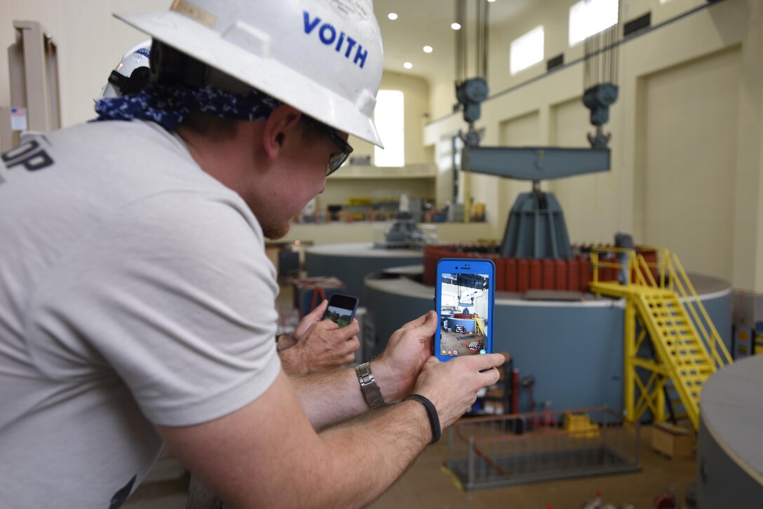 Justin Botkin, Voith Hydro employee, takes a picture of a 249-ton rotor being installed into hydropower unit two at Center Hill Dam in Lancaster, Tenn., June 19, 2017. The U.S. Army Corps of Engineers Nashville District is rehabilitating the unit and expects to bring it online in late July after the completion of its assembly and load testing.