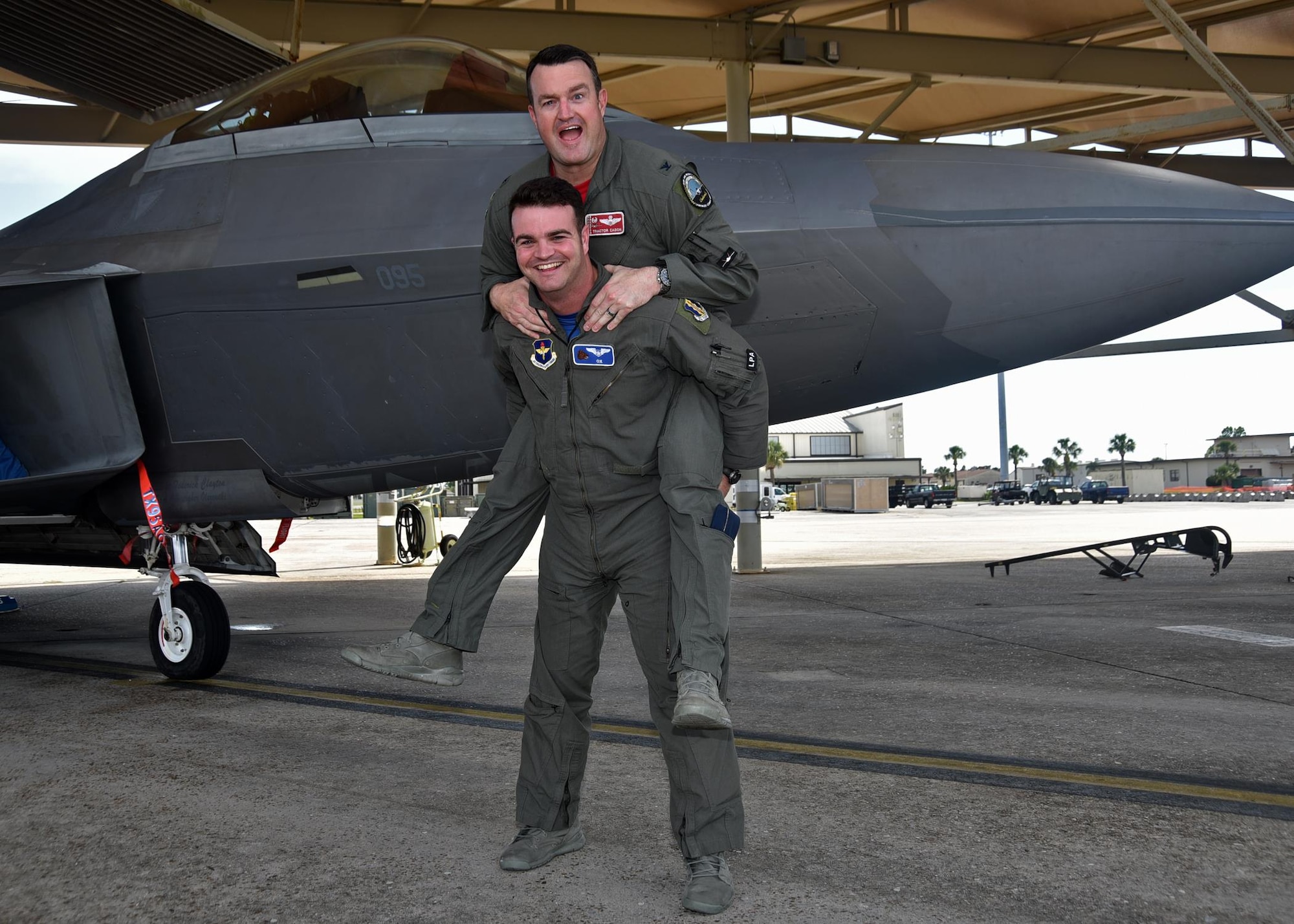 U.S. Air Force Col. Randall W. Cason, 44th Fighter Group commander, and his son 2nd Lt. Randall W. Cason III, 337th Air Control Squadron Air Battle Manager, share a special moment in front of an F-22 Raptor at the Tyndall Air Force Base, Fla., flightline June 16, 2017. As an Air Battle Manager, 2nd Lt. Cason provides command and control to aircraft during combat operations and had the opportunity to support his father during a training mission over the Gulf Coast waters. (U.S. Air Force photo by Senior Airman Sergio A. Gamboa/Released)