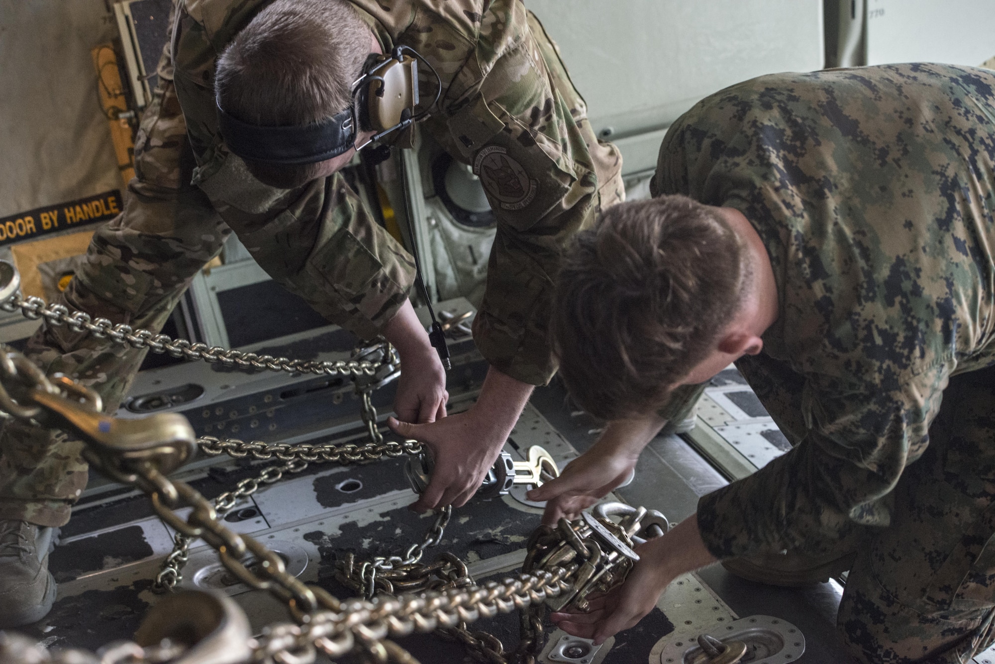 A U.S. Air Force 17th Special Operations Squadron loadmaster and a 12th Marine Regiment, 3rd Marine Division operator secure a High Mobility Artillery Rocket System (HIMARS) following a readiness drill, June 1, 2017 at Kunsan Air Base, Republic of Korea. The tactical level exchanges and realistic scenario-based mission executed during the joint training exercise increased interoperability and partner capacity with between the U.S Air Force and Marine Corps. (U.S. Air Force photo by Capt. Jessica Tait)