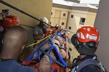 Firefighters from the Pacific Air Forces region raise a Stokes basket over a rail during the Department of Defense Technical Rescue Course at Kunsan Air Base, Republic of Korea, June 8, 2017. Students learned how to save victims who may be trapped on roof tops, inside elevator shafts, or on hard-to-reach mountainous terrain. (U.S. Air Force photo by Senior Airman Michael Hunsaker/Released)