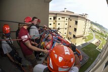 Firefighters from the Pacific Air Forces region raise a Stokes basket over a rail during training at Kunsan Air Base, Republic of Korea, June 8, 2017. The firefighters participated in the Department of Defense Technical Rescue Course where students learned to save victims that may be trapped on roof tops, inside elevator shafts or hard-to-reach mountainous terrain. (U.S. Air Force photo by Senior Airman Michael Hunsaker/Released)